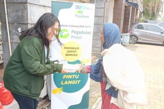 Petugas pegadaian membagikan makanan kepada masyarakat dalam kegiatan Jumat Berkah.
