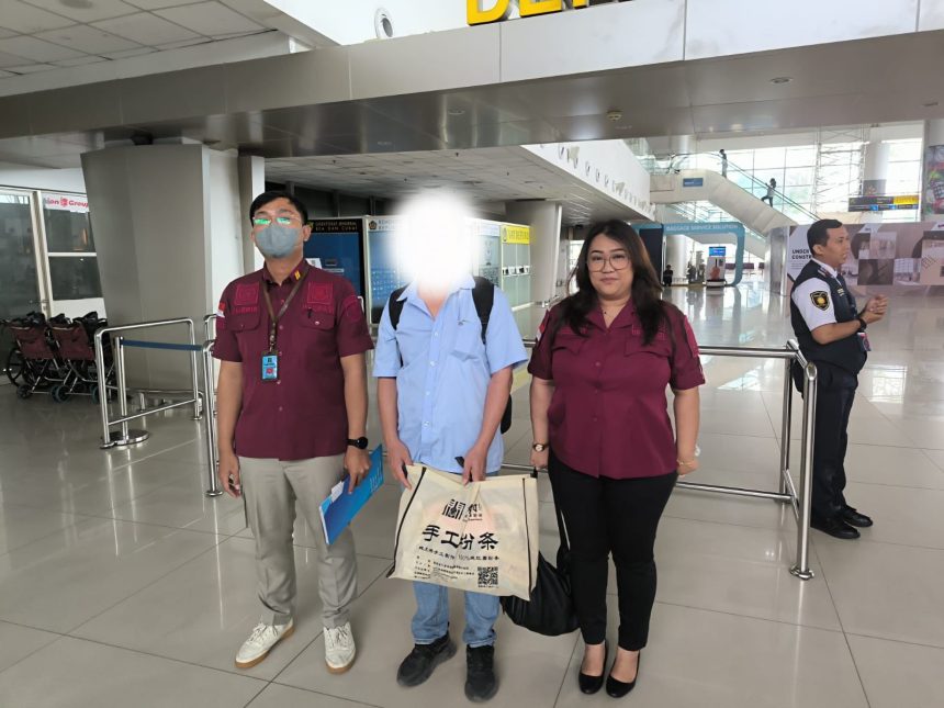 Petugas mengawal LW, Warga Negara China di Bandara Internasional Juanda untuk dipulangkan ke negara asal.