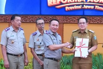 Kakanwil BPN Jatim, Lampri, A.Ptnh., menyerahkan sertifikat elektronik kepada Pj. Gubernur Jawa Timur, Adhy Karyono didampingi para kepala Kantah Sidoarjo, dan Gresik. 