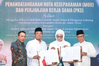 Kakanwil BPN Jatim Lampri (kiri) mendampingi Menteri Nusron Wahid menunjukkan MoU bersama Ketua PWNU Jatim KH Abdul Hakim Mahfudz.