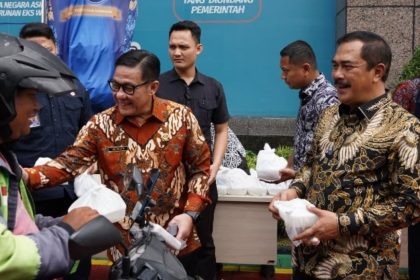 Plt Dirjen Imigrasi Saffar Muhammad Godam berbagi bingkisan bersama Menteri Imigrasi dan Pemasyarakatan, Agus Andrianto (kanan) dalam kegiatan bakti sosial serentak kemarin.
