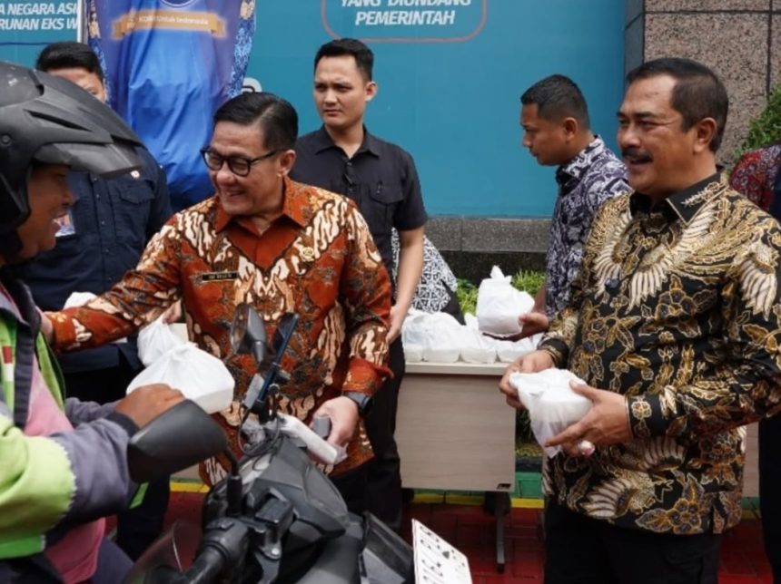 Plt Dirjen Imigrasi Saffar Muhammad Godam berbagi bingkisan bersama Menteri Imigrasi dan Pemasyarakatan, Agus Andrianto (kanan) dalam kegiatan bakti sosial serentak kemarin.