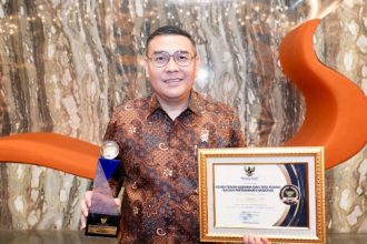 Wakil Menteri ATR/Wakil Kepala BPN, Ossy Dermawan menunjukkan penghargaan yang diterima dari Komisi Informasi Pusat (KIP). 