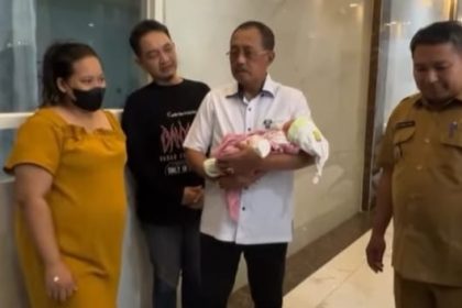 Wakil Wali Kota Armuji menggendong bayi dari Ny Siti yang tersandung masalah biaya persalinan.
