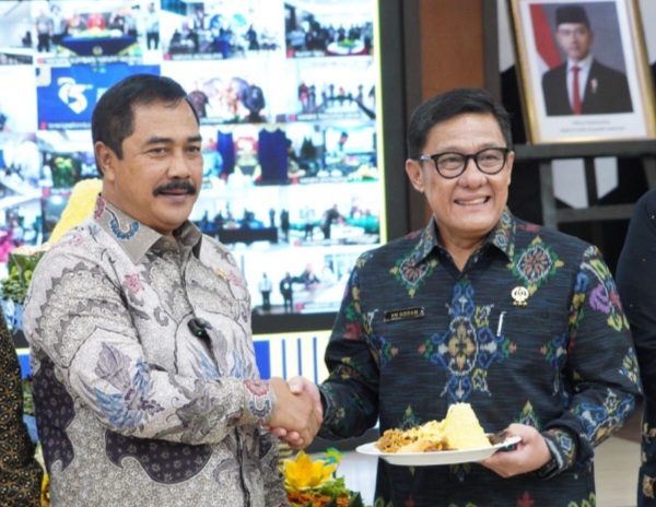 Menteri Imigrasi dan Pemasyarakatan Agus Andrianto menyerahkan potongan tumpeng kepada Plt Dirjen Imigrasi, Saffar Muhammad Godam dalam acara puncak HBI.