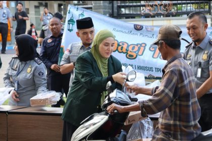 Petugas Imigrasi Surabaya membagikan takjil kepada pengguna jalan yang melintas di depan kantor di Jalan Juanda, Sedati, Sidoarjo.