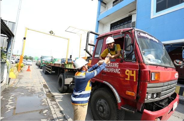 Seorang sopir trailer yang melintas di pintu masuk pelabuhan mendapat paket makan gratis.