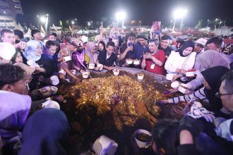 Warga Surabaya berebut rujak uleg yang digelar di THR Surabaya.