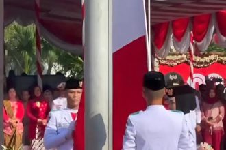 Bendera Merah Putih dengan kondisi terbalik oleh paskriba saat upacara HUT Republik Indonesia Ke-80 di Balai Kota Surabaya.