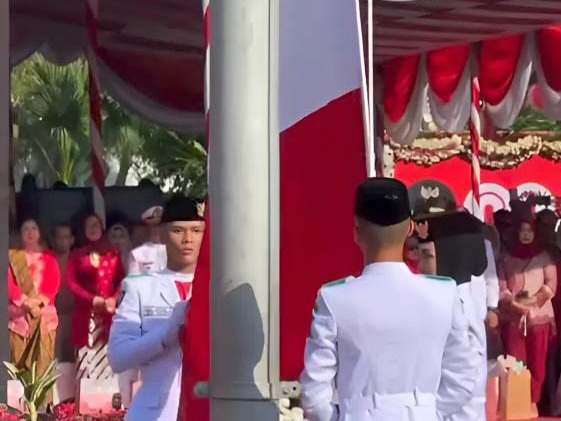 Bendera Merah Putih dengan kondisi terbalik oleh paskriba saat upacara HUT Republik Indonesia Ke-80 di Balai Kota Surabaya.