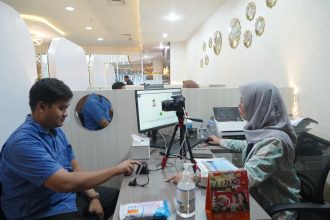 Petugas imigrasi memberikan pelayanan Paspor Simpatik kepada pemohon pada wekeend.