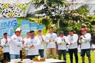 Pembina Askring Kantor Club, Chandra memberikan potongan tumpeng kepada anggota.