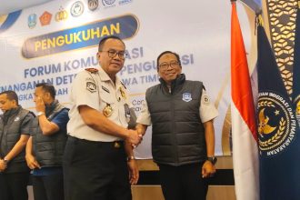 Kakanwil Ditjen Imigrasi Jawa Timur, Novianto Sulastono, menyematkan rompi kepada anggota Forkopdensi dalam agenda workshop di hotel Surabaya.