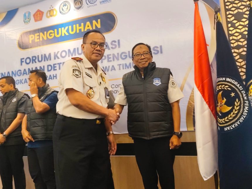 Kakanwil Ditjen Imigrasi Jawa Timur, Novianto Sulastono, menyematkan rompi kepada anggota Forkopdensi dalam agenda workshop di hotel Surabaya.