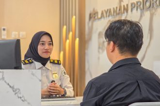 Petugas Imigrasi Surabaya memberikan penjelasan kepada pemohon paspor menyoal jam pelayanan selama Ramadan.