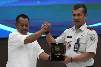 Ketua PWI Jatim Lutfil Hakim (kiri) menerima cenderamata dari Kepala Kantor Imigrasi Surabaya, Agus Winarto.