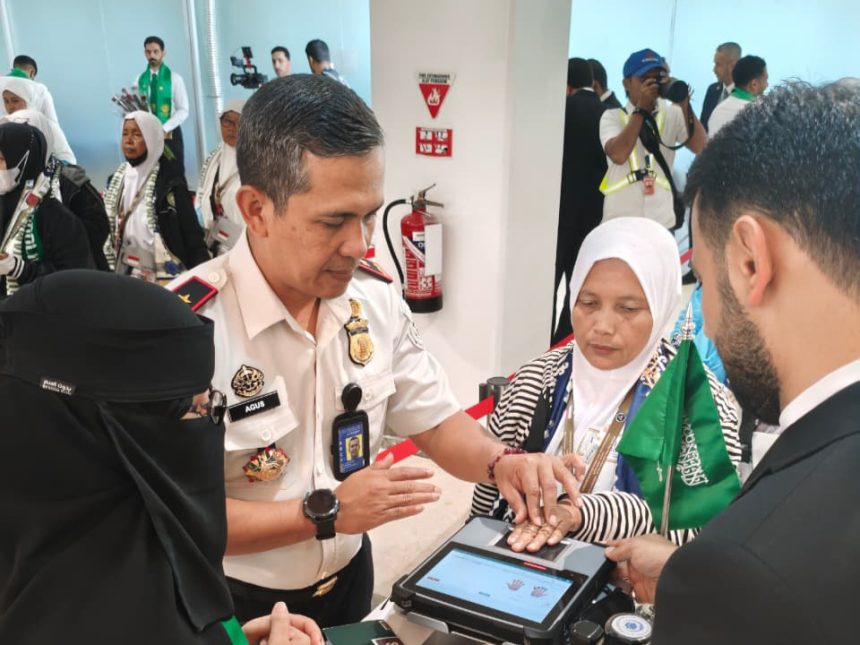 Kepala Kantor Imigrasi Kelas I Khusus TPI Surabaya, Agus Winarto, membantu jemaah haji siang sidik jari sebagai bentuk pengecekan dokumen secara digital.