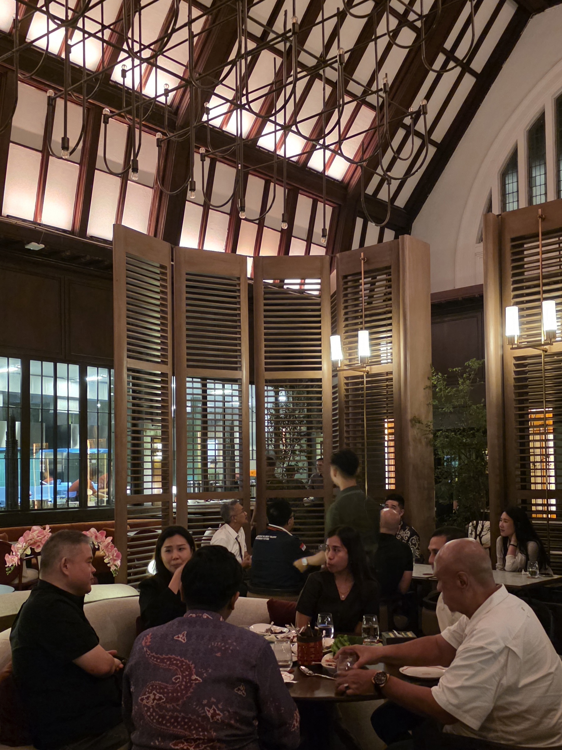 Pengunjung merasakan pengalaman santap malam di tengah pesona bangunan bersejarah, dengan ornamen klasik dan pencahayaan temaram yang menciptakan suasana intim.