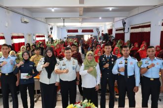 Jajaran Imigrasi Kediri diwakili Kasi Tikkim, Nasrullah bersama Kepala sekolah SMKN 2 Jombang, Amiroh, dan seluruh peserta sosialisasi berfoto bersama usai kegiatan.