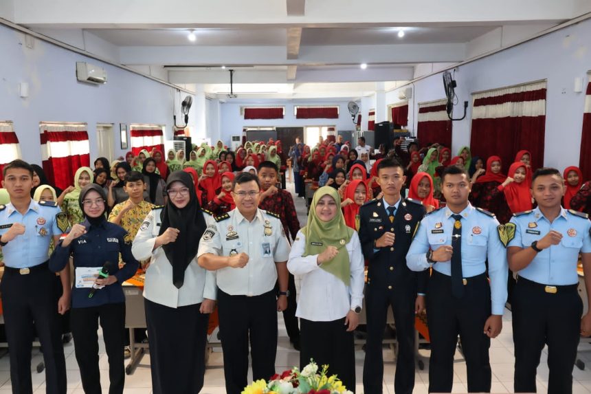 Jajaran Imigrasi Kediri diwakili Kasi Tikkim, Nasrullah bersama Kepala sekolah SMKN 2 Jombang, Amiroh, dan seluruh peserta sosialisasi berfoto bersama usai kegiatan.
