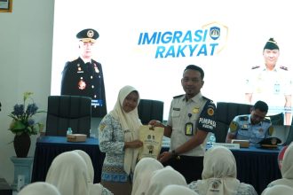 Petugas Kantor Imigrasi Kelas II Non TPI Kediri saat memberikan cinderamat dalam kegiatan edukasi kepada pelajar SMAN 1 Jombang.