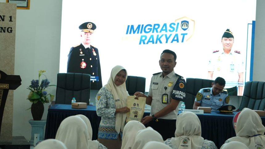 Petugas Kantor Imigrasi Kelas II Non TPI Kediri saat memberikan cinderamat dalam kegiatan edukasi kepada pelajar SMAN 1 Jombang.
