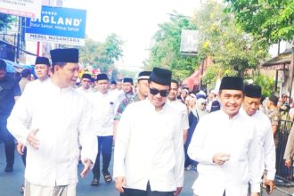 Tiga tokoh berjalan bersama di tengah lautan jamaah, menuju rangkaian puncak Haul ke-45 KH Abdul Hamid di Kota Pasuruan.