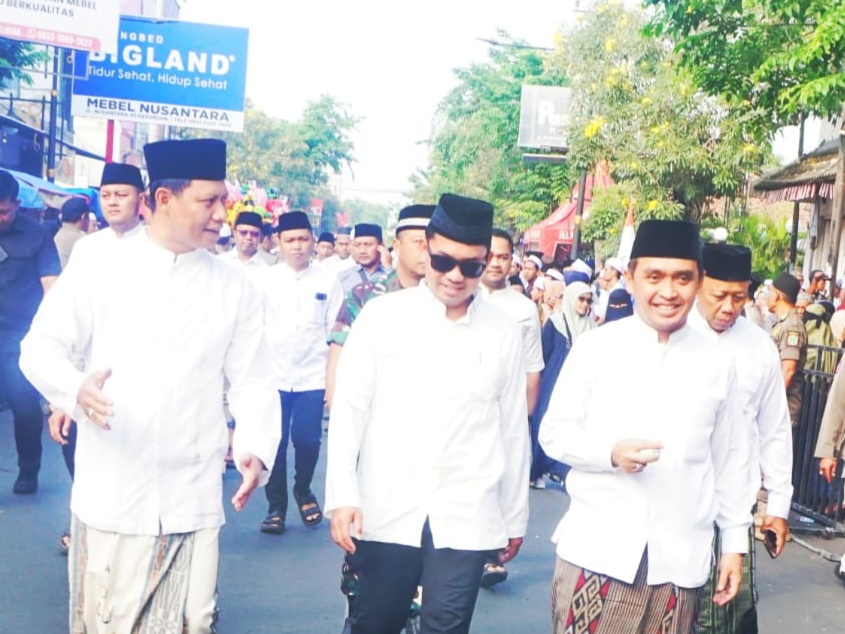 Tiga tokoh berjalan bersama di tengah lautan jamaah, menuju rangkaian puncak Haul ke-45 KH Abdul Hamid di Kota Pasuruan.