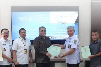 Kepala Kantor Pertanahan Kabupaten Jombang Wawas Setiawan, S.SiT., M.M. (dua dari kiri) menyaksikan penyerahan sertifikat.